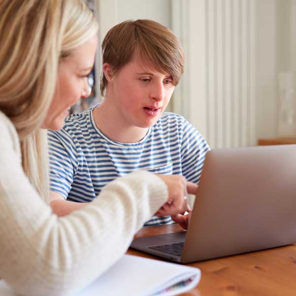 Mann mit Down-Syndrom wird von einer Heimlehrerin zu Hause betreut